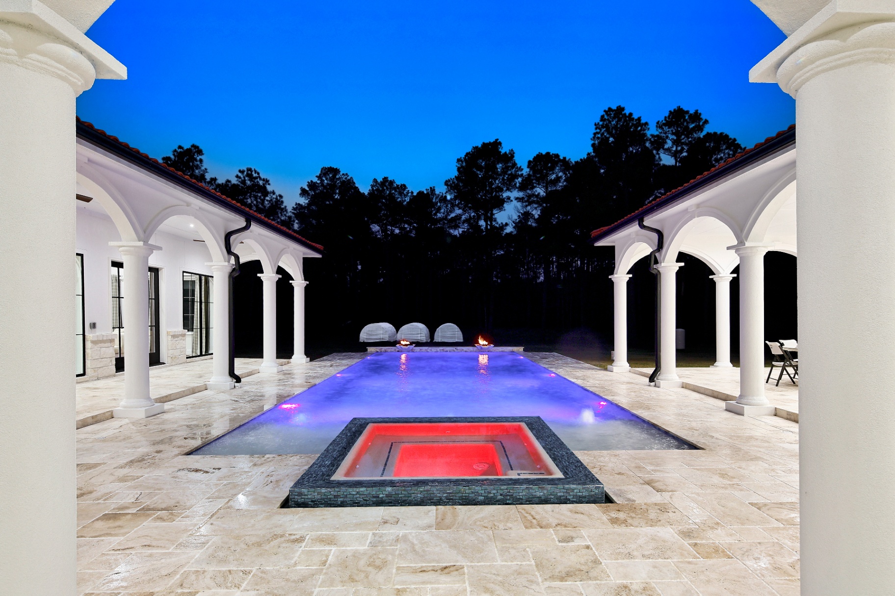 Resort pool and spa framed by Mediterranean arches at twilight